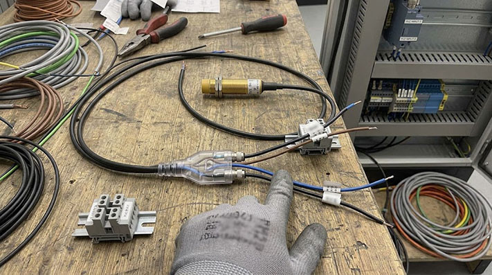 A simple wiring diagram showing a 3-wire sensor connected to an M8 Y-splitter, with the single Power, Ground, and Signal lines being duplicated to two separate output connectors.