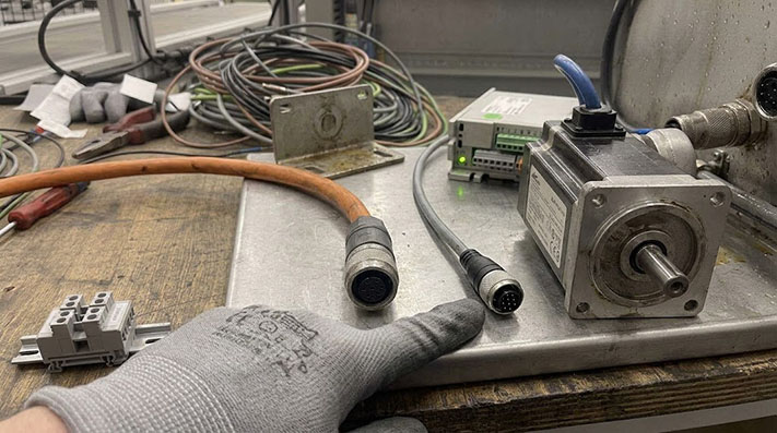 A diagram showing a servo drive, a servo motor, and the two connecting cables: a power cable and an encoder feedback cable.
